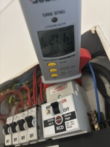 Clamp meter testing leakage at an RCD fuse board